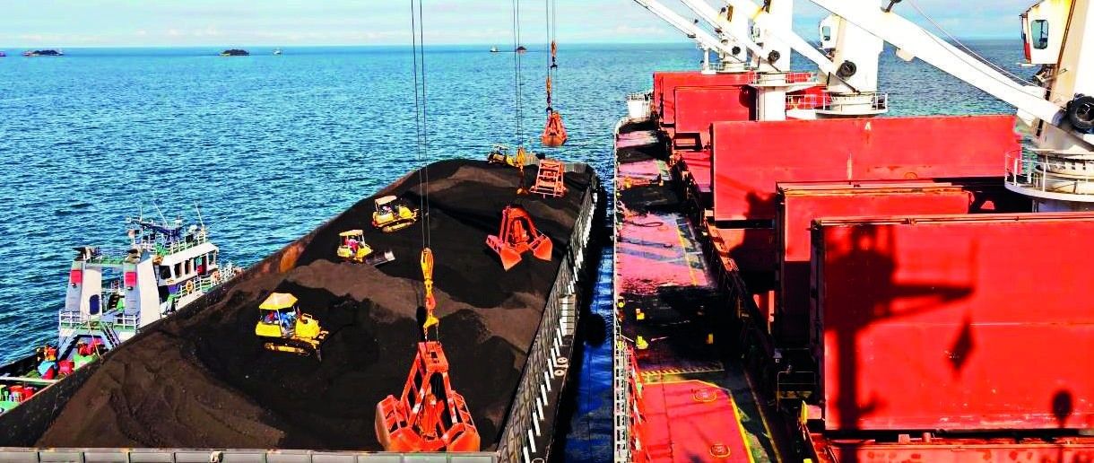 Grab discharging dry bulk cargo into a barge alongside a bulk carrier